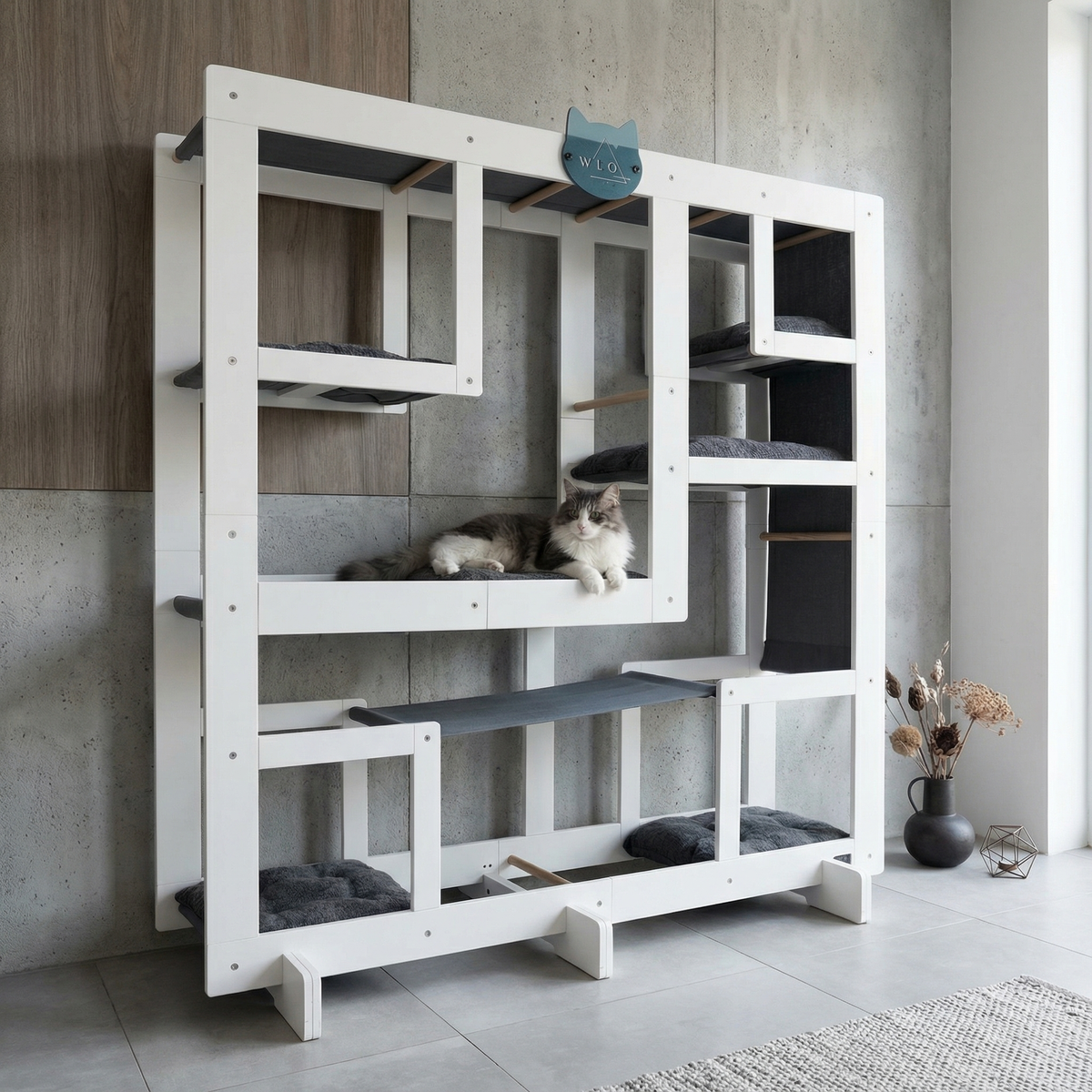 White cat tree with multiple levels and a cat sitting on one of the shelves.