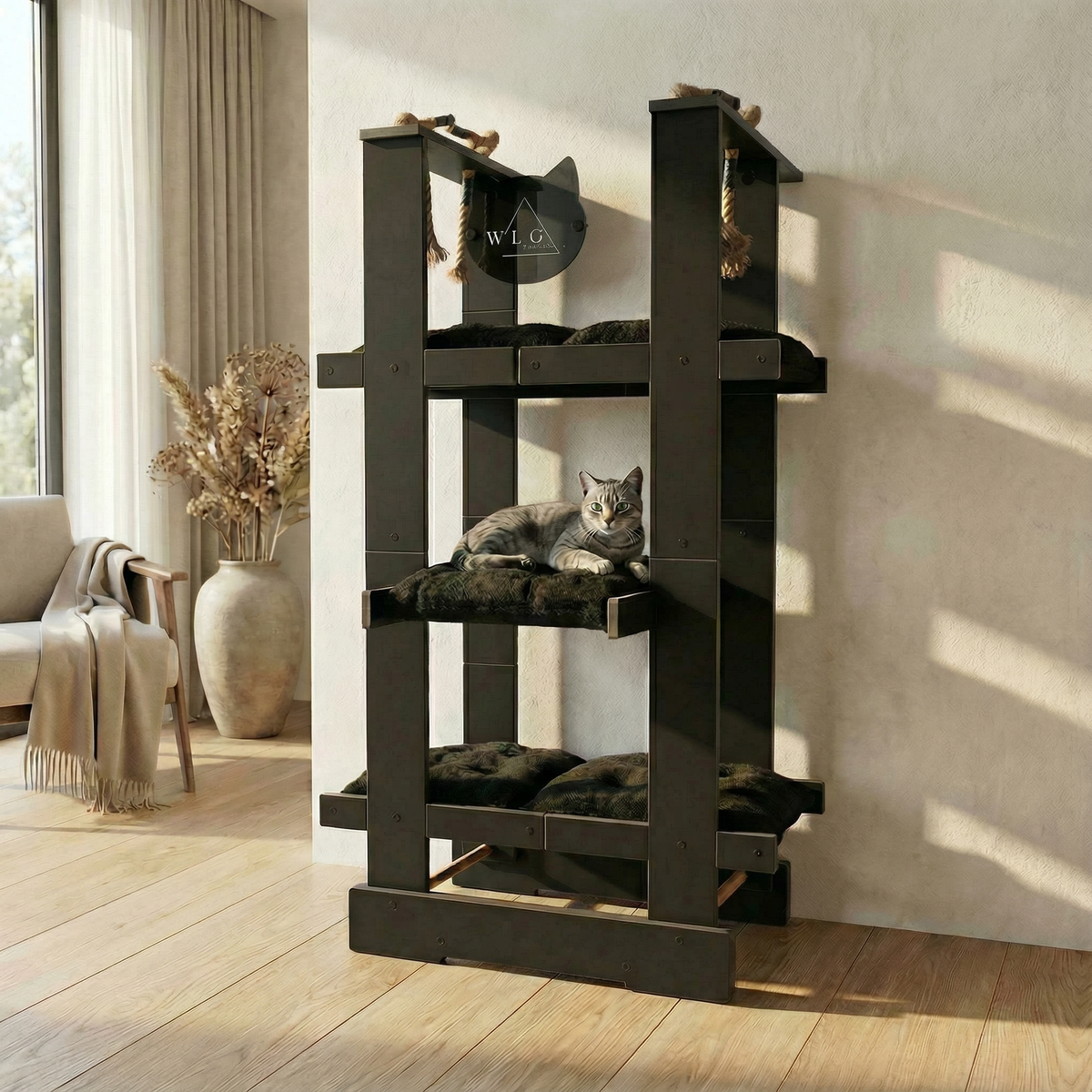 Cat tree with a cat resting on it in a room with a window and vase.